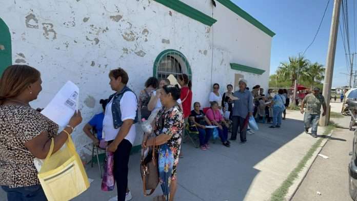 Pese al sol, las beneficiarias esperaron por varias horas para realizar su trámite