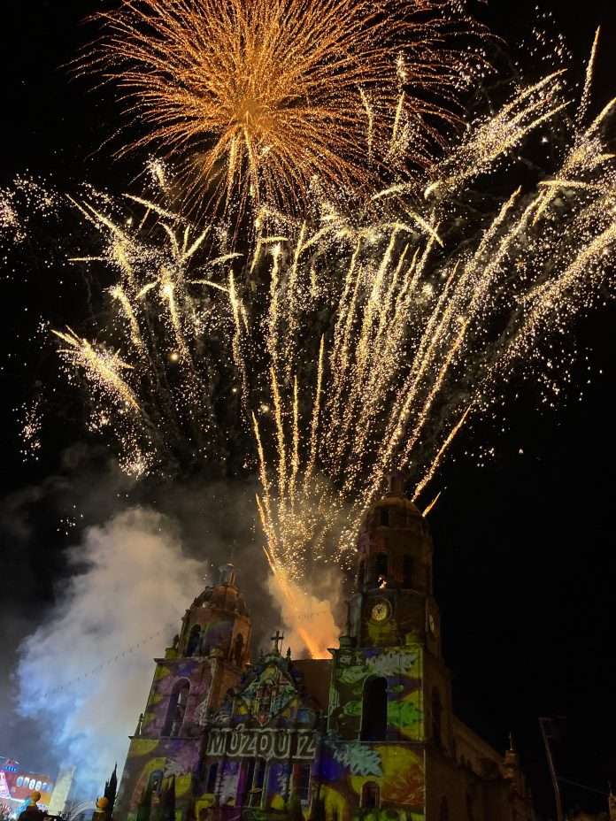Plaza principal de Múzquiz llena de asistentes durante los festejos de Santa Rosa de Lima con video mapping y fuegos pirotécnicos.