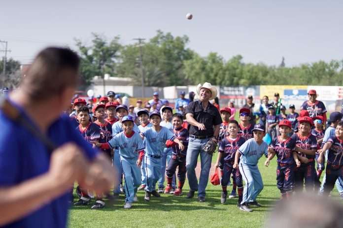 Chano Díaz Iribarren lanza la primera bola en la inauguración de la Liga Infantil de Béisbol Sabinas.