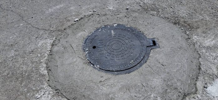 tienden reparación de tapa de drenaje en la carretera Sauz-Palaú de Minas de Barroterán para reducir riesgos y mejorar la seguridad vial.